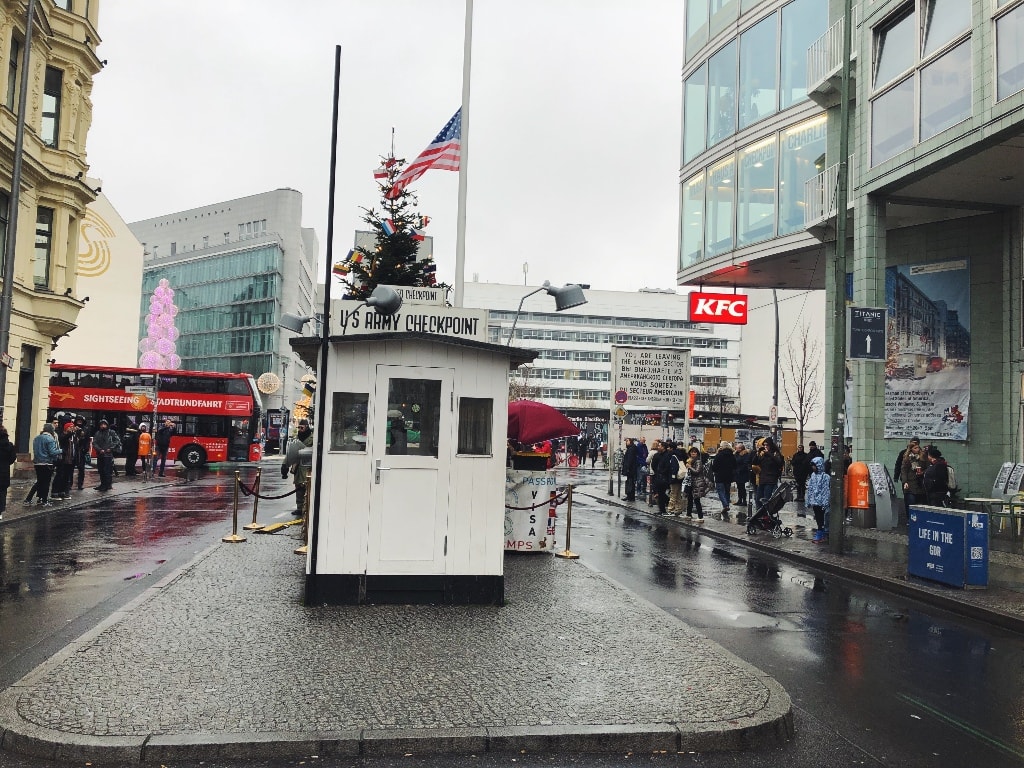Checkpoint Charlie with sign post and KFC in background